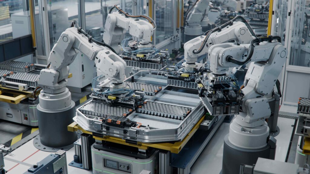 Industrial Robot Arms Assemble Lithium-Ion EV Battery Pack. Row of White Robotic Arms at Automated Production Line at Bright Modern Factory. Electric Car Manufacturing Inside Automotive Smart Factory